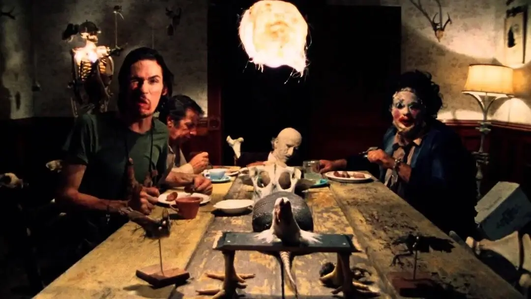 Cena de O Massacre da Serra Elétrica que mostra a familia de Letherface jantando em volta de uma mesa. Post sobre Filmes de Terror Baseados em Fatos Reais